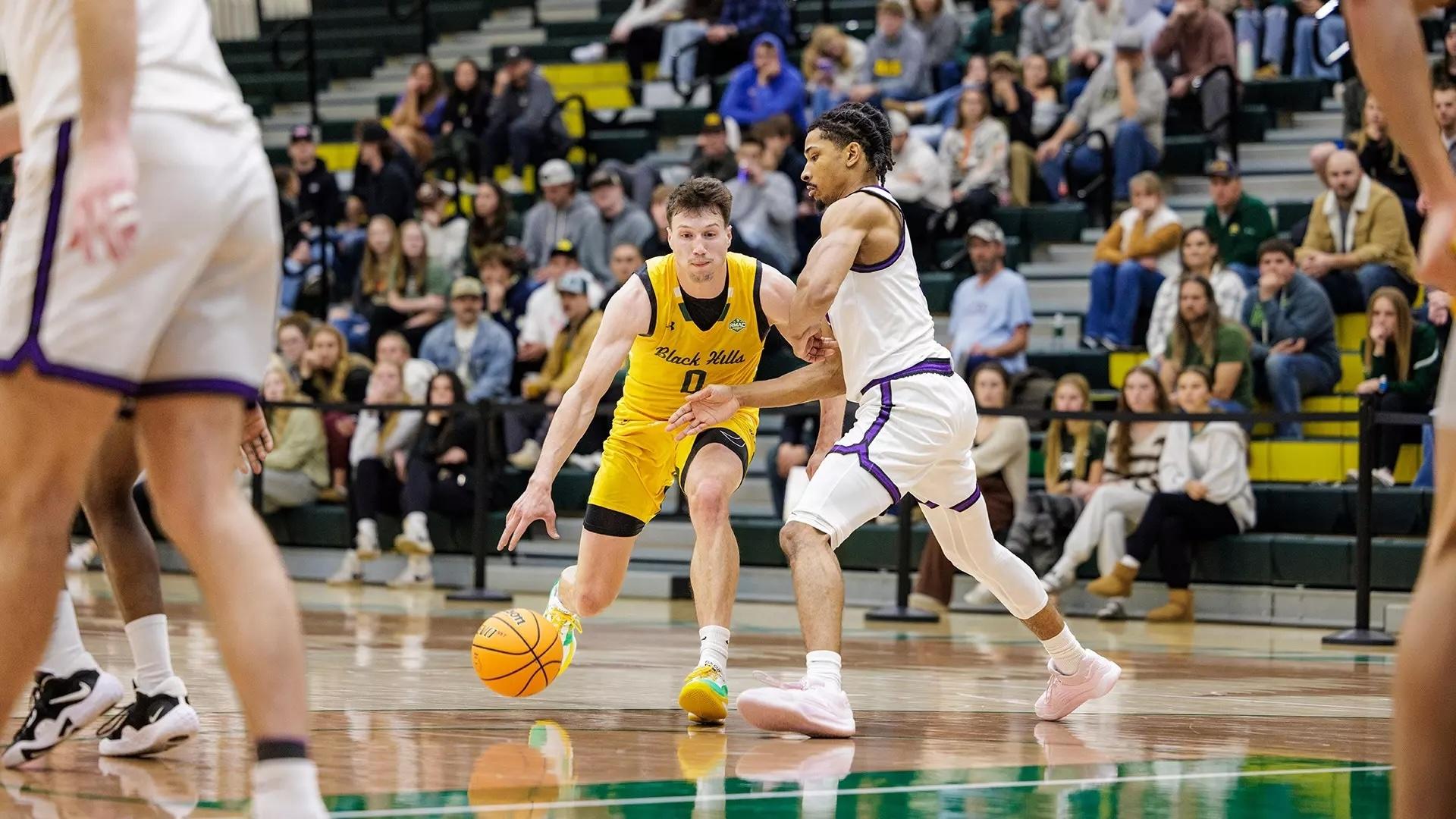 Cam Lowe drives the basketball for Black Hills State.